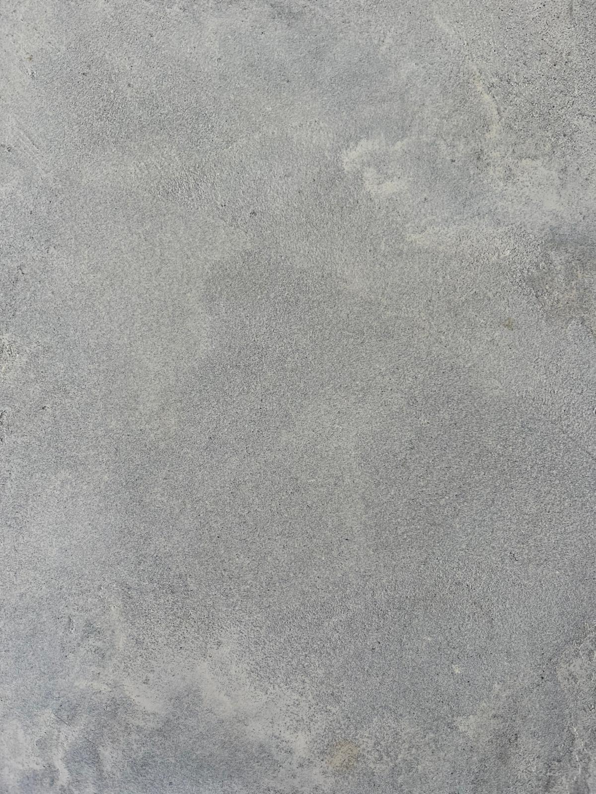 Pure mid-grey microcement surface showing soft cloud-like mottling
