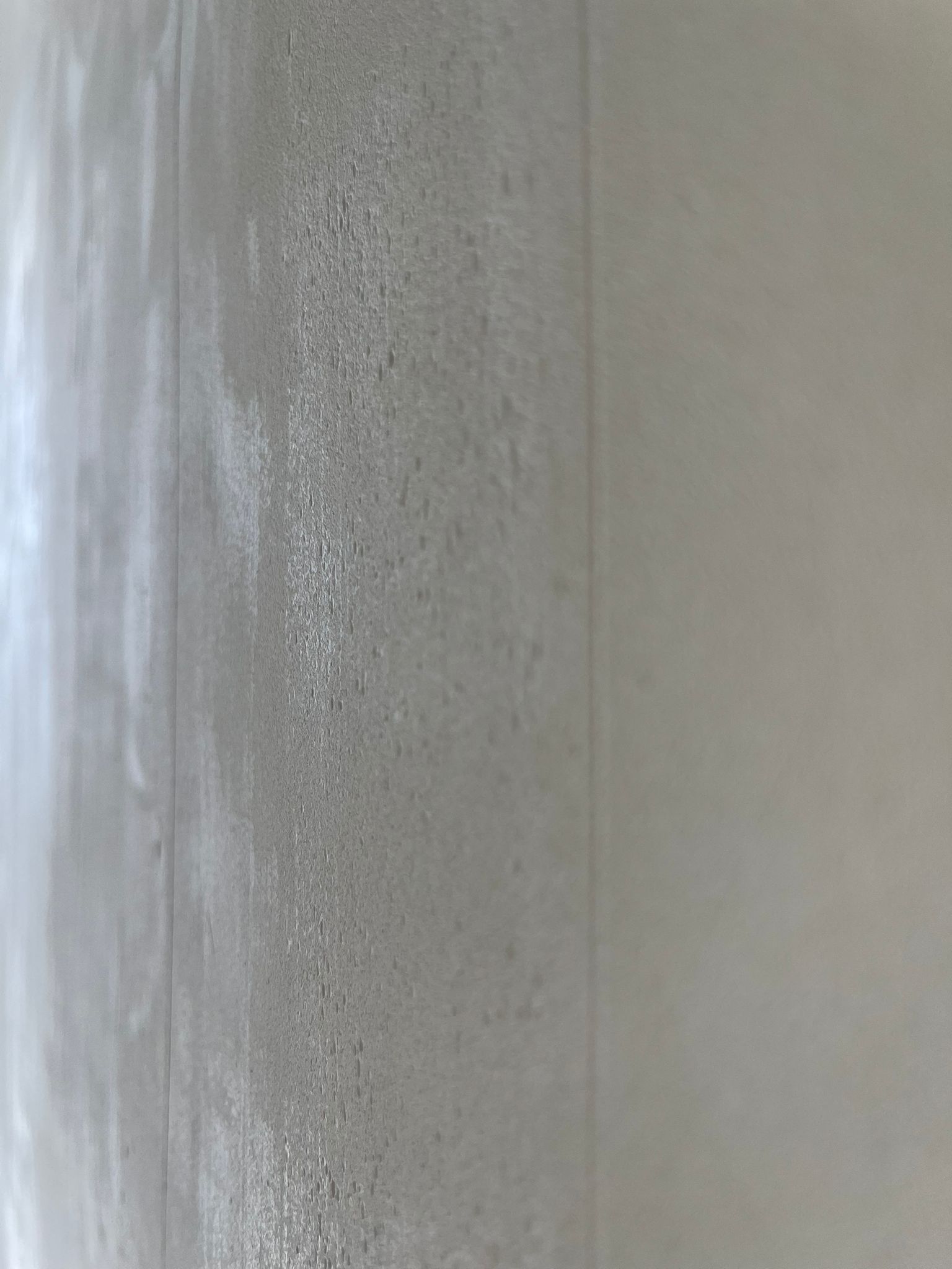 Curved microcement wall corner showing smooth-to-textured transition